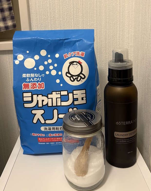 わが家の洗濯コーナー。シャボン玉石けんのスノールと、木のスプーンを入れたクエン酸のびん、ドテラの洗濯洗剤